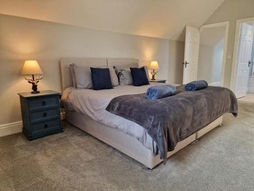 a bedroom with a large bed with blue pillows at Southbarn - Spectacular Country Home in Winestead