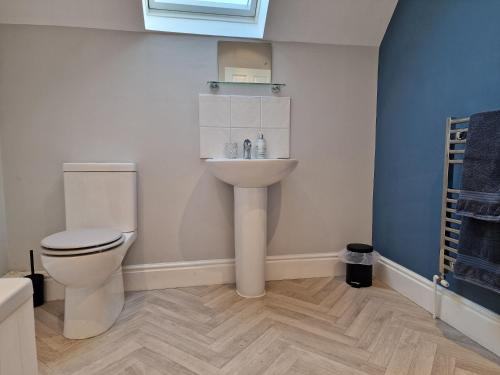 a bathroom with a toilet and a sink at Southbarn - Spectacular Country Home in Winestead