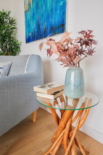 a glass table with a blue vase on top of books at PRECIOSO y EXCLUSIVO APARTAMENTO EN 1º LINEA DE PLAYA CON PARKING in Almuñécar