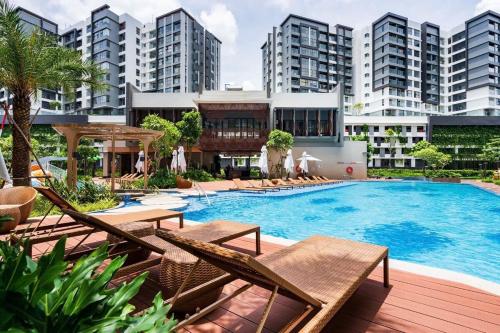 an outdoor swimming pool with lounge chairs and buildings at Nhà của Hải - Apartment Luxury Diamond Brilliant in Ho Chi Minh City