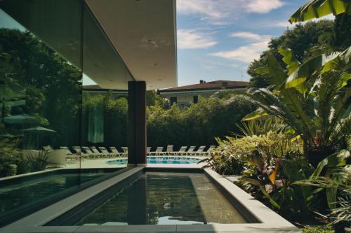 a swimming pool in the middle of a house at Villa Nicolli Romantic Spa Resort - Adults Only in Riva del Garda