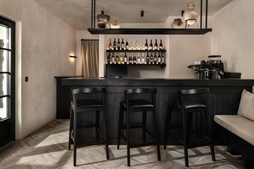 a bar with stools in a room with a couch at Abella Suites Embonas in Émbonas