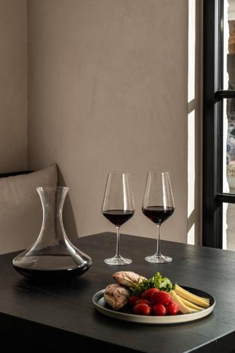 a table with two glasses of wine and a plate of food at Abella Suites Embonas in Émbonas