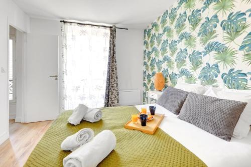 a bedroom with a bed with a tray of towels on it at 866 Suite Lilas - Superbe appartement in Montreuil