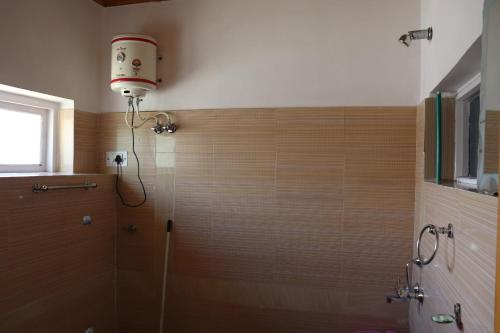 a bathroom with a shower with a glass door at Nilza Guest House in Leh