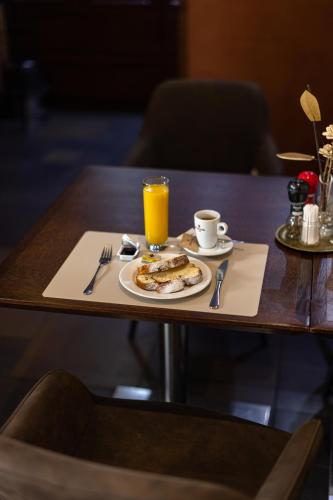 a table with a plate of food and a glass of orange juice at Penzion Royal in Trenčín