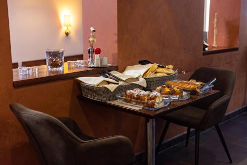 a table with a tray of bread and pastries on it at Penzion Royal in Trenčín