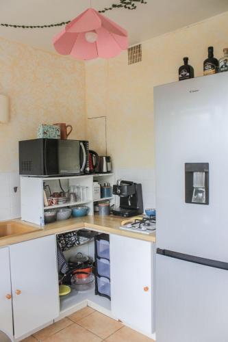 a kitchen with white cabinets and a white refrigerator at Le château in Blanquefort