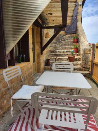 - une table et des chaises sur une terrasse avec des escaliers dans l'établissement Corps de ferme rénové à 10 min de Sarlat, à Carsac-Aillac
