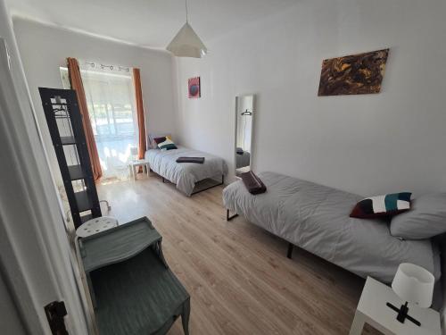 a small room with two beds and a chair at Peaceful Stay - Lisbon in Amadora