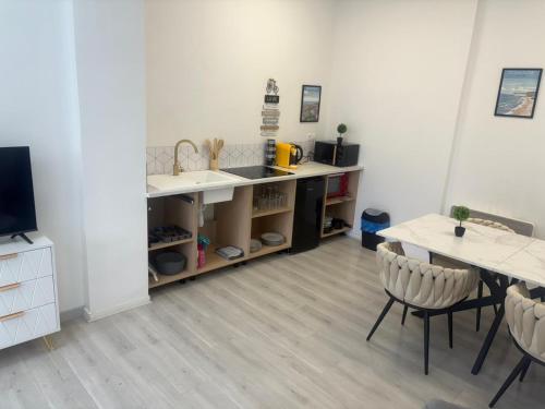 a kitchen with a sink and a table with chairs at cosy 50m2 avec spa et jardin in Boulogne-sur-Mer