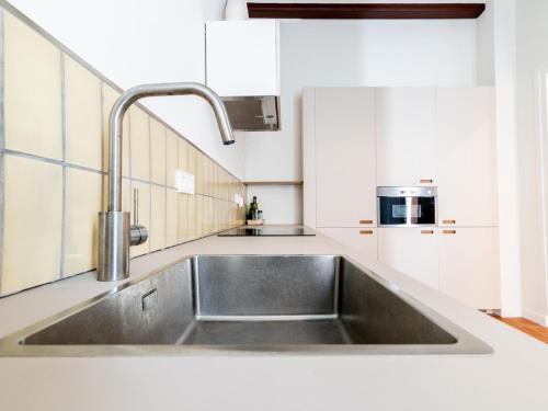 a stainless steel sink in a kitchen with white cabinets at Winahost Casa a Sant Feliu de Guíxols in Sant Feliu de Guixols