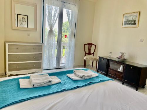 a bedroom with a bed with two towels on it at La Maison de la Riviere in Lefkímmi
