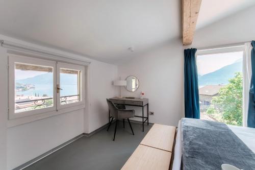 a bedroom with a bed and a desk with a window at Luce & Olive - by MyHomeInComo in Acquaseria