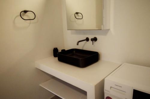 a bathroom with a black sink on a white counter at Faragnanti #2 in Gythio