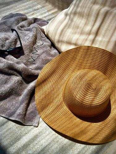 a straw hat sitting on top of a pile of clothes at Ammoo in Amoopi
