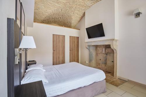 a bedroom with a bed and a tv on the wall at Appart'hôtel Odalys City - Dijon Centre Les Cordeliers in Dijon