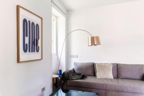 a living room with a couch and a lamp at Luce & Olive - by MyHomeInComo in Acquaseria