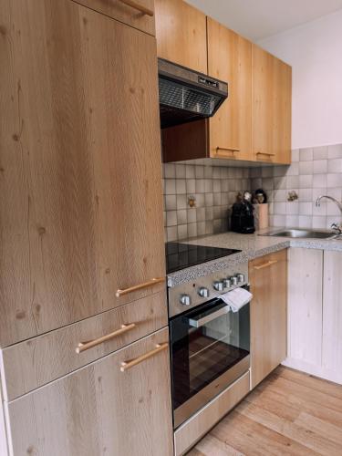 a kitchen with wooden cabinets and a stove top oven at Das Luis in Altenmarkt im Pongau