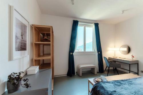a bedroom with a bed and a desk and a window at Luce & Olive - by MyHomeInComo in Acquaseria