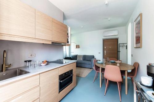 a kitchen and living room with a table and chairs at Luce & Olive - by MyHomeInComo in Acquaseria