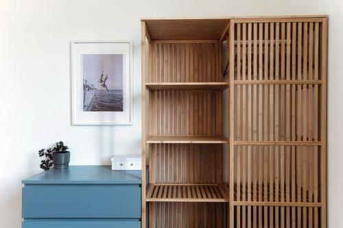a wooden book shelf in a room with a blue desk at Luce & Olive - by MyHomeInComo in Acquaseria