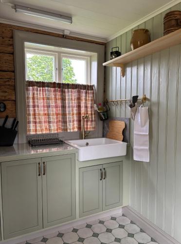 a bathroom with a sink and a window at Brygghuset in Skillingaryd