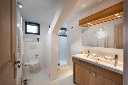 a bathroom with a sink and a toilet and a mirror at Résidences Alticimes in Brides-les-Bains