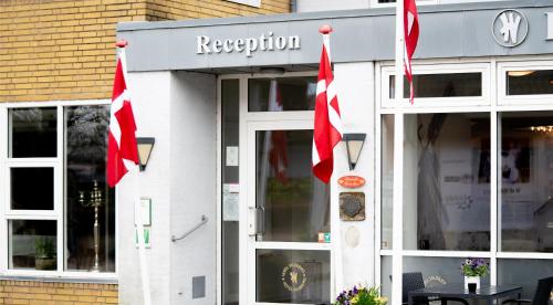 a restaurant with red flags in front of it at Hotel Vildbjerg in Vildbjerg