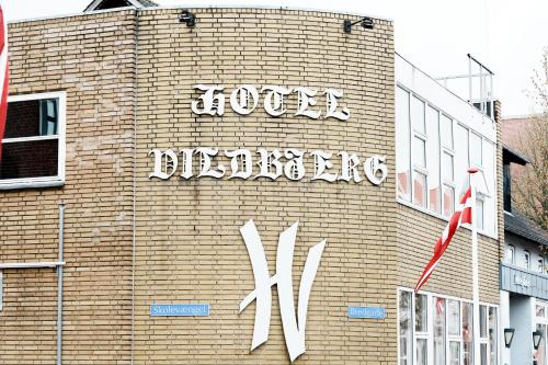 a building with a sign on the side of it at Hotel Vildbjerg in Vildbjerg