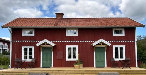 a red house with white windows and green doors at Brygghuset in Skillingaryd