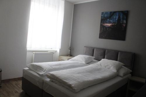 a bedroom with a bed with white sheets and a window at Hotel Palác in Olomouc