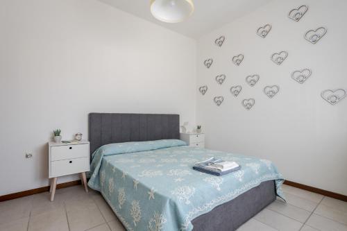 1 dormitorio con 1 cama con corazones en la pared en A pochi passi dal mare Appartamento in centro, en Lido di Jesolo