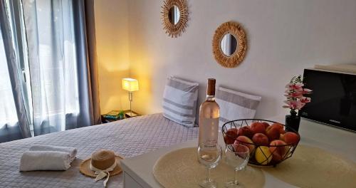 une bouteille de vin et un bol de pommes sur un lit dans l'établissement Provence apartments, à Aix-en-Provence