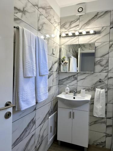 a bathroom with a white sink and a mirror at Sunlit Serenity in Paphos in Paphos