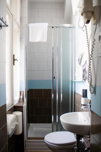 a bathroom with a shower and a toilet and a sink at Prague Dream Hostel in Prague