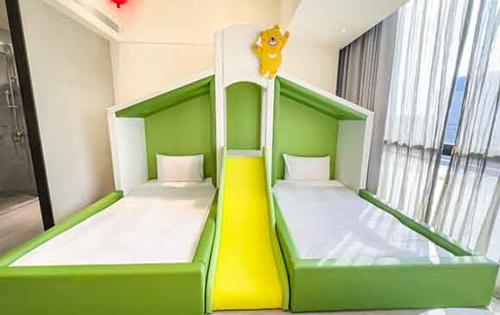 a green and white bunk bed in a room at Hsin Hotel in Chiayi City