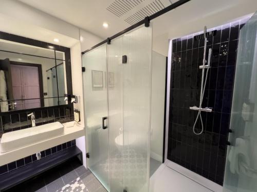 a bathroom with a glass shower and a sink at Hotel Indigo Madrid - Gran Vía by IHG in Madrid