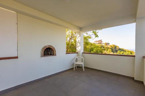 an empty room with a chair and a window at Villa Tina in Patti