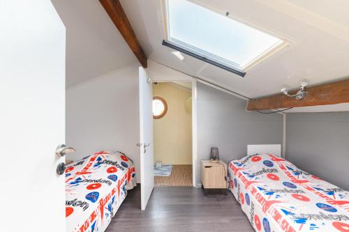 - une chambre avec 2 lits et une lucarne dans l'établissement Le Loft Sablais, 3 étoiles de l'Office de Tourisme, à Les Sables-dʼOlonne