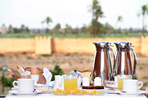 a table with a breakfast of eggs bread and coffee at Rawabi Hotel Marrakech & Spa in Marrakech