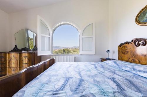 a bedroom with a large bed and two windows at Villa Tina in Patti
