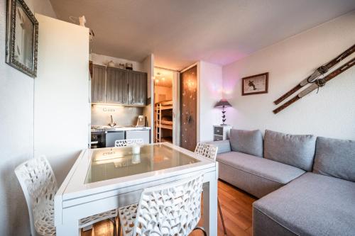 a living room with a couch and a table at Studio de charme in Bogève