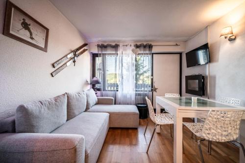 a living room with a couch and a table at Studio de charme in Bogève