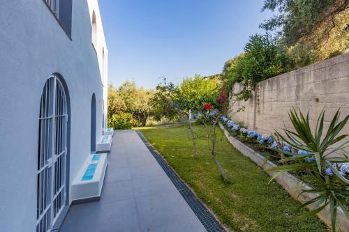 a walkway next to a building and a retaining wall at Villa Tina in Patti