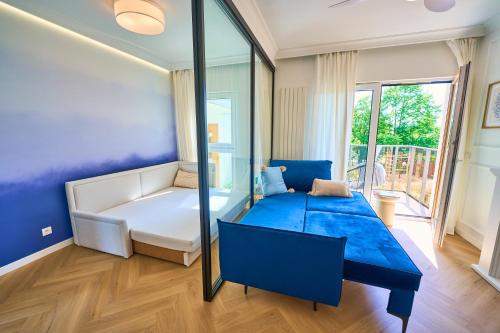 a blue and white room with a couch and a table at BLISKO Plaży in Gdańsk