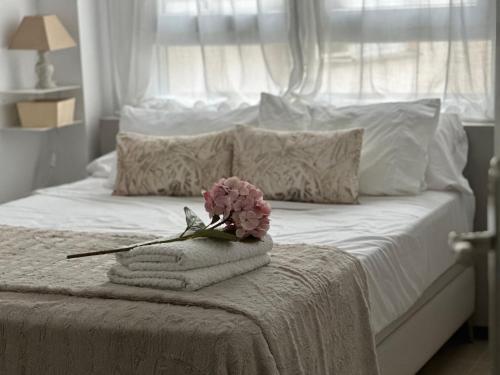 a white bed with towels and a flower on it at Apartamento en la Playa Benicarló Peñíscola in Benicarló