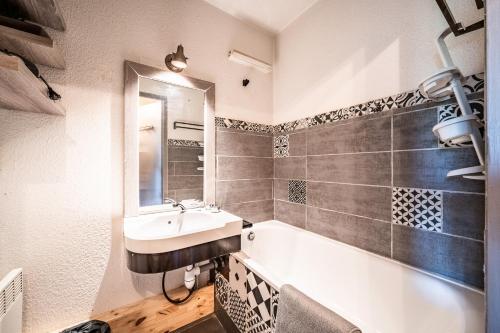 a bathroom with a sink and a bath tub at Studio de charme in Bogève