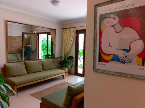 a living room with a couch and a painting on the wall at Cunda Alibeyhan Otel in Cunda