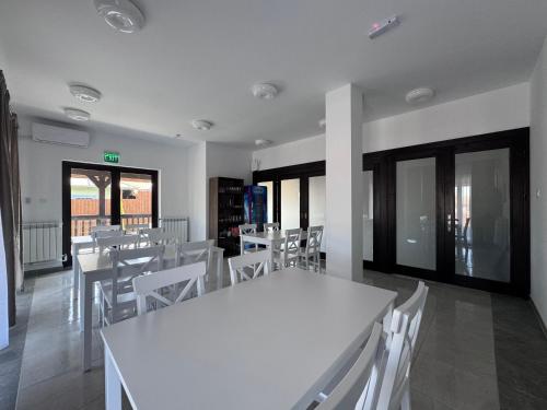 a dining room with white tables and white chairs at Delta MEO in Mahmudia